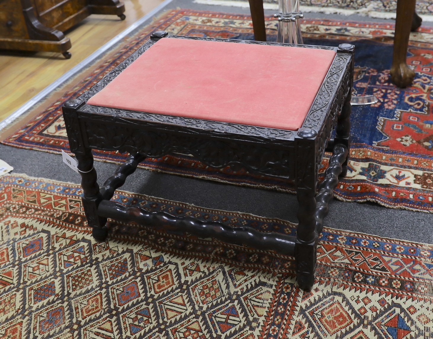 A 19th century Indian carved ebony stool, length 56cm, depth 46cm, height 40cm